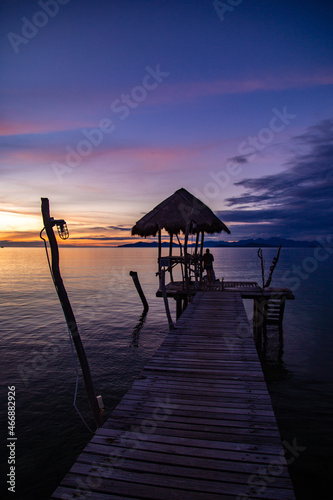 Sunset over wooden beach bar in sea and hut on pier in koh Mak island, Trat, Thailand