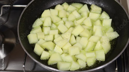 Cube potatoes frying in olive oil. Perspective view