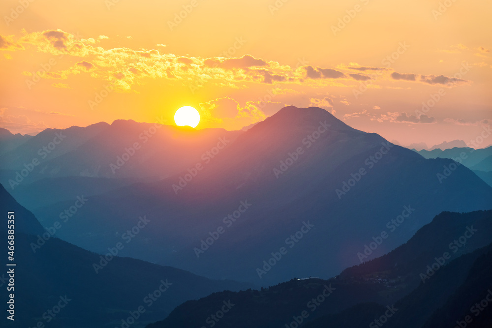 Sun setting behind mountains