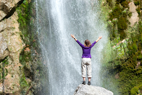 Happy girl near a big waterfall