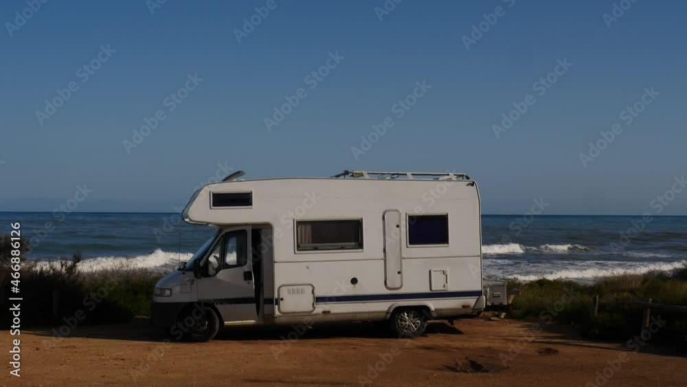 Santa Pola, Valencia, Spain - December 6, 2019: Autocaravan Chausson camping on sea shore. Sea waves moving in slow motion. Spain, Costa Blanca. Santa Pola, Valencia, Spain - December 6, 2019: Autocaravan Chausson camping on sea shore. Sea waves moving in slow motion. Spain, Costa Blanca.