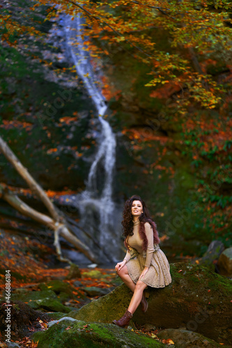 Beautiful young woman by a waterfall