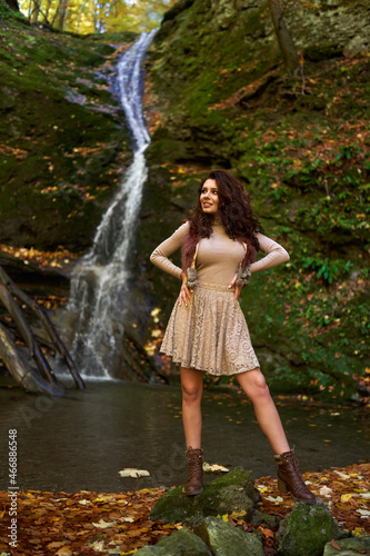 Beautiful young woman by a waterfall