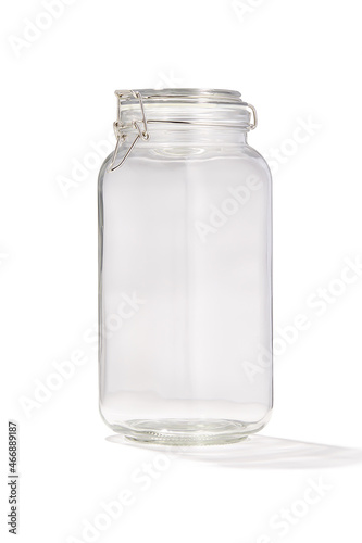 Detailed shot of a glass jar. Kitchen tableware is transparent. The jar with lid is isolated on the white background.
