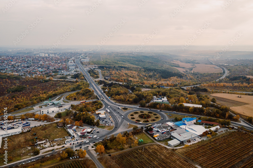 Obraz premium Aerial view of a road system passing among autumn city landscape. Wallpaper Earth environment