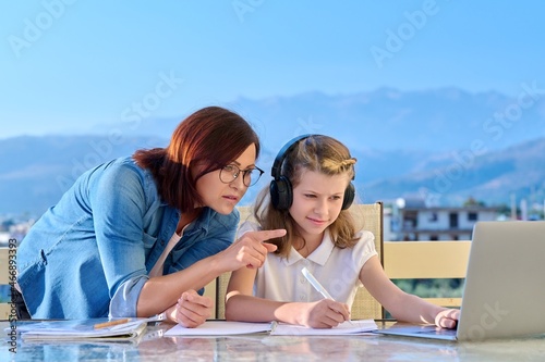 Child schoolgirl learning online with laptop, mom helping © Valerii Honcharuk