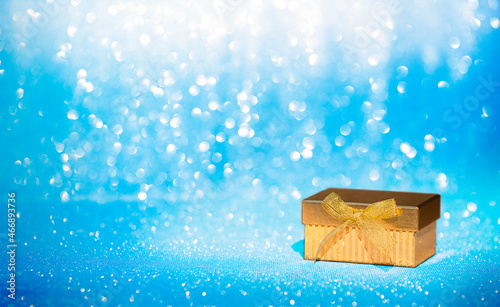 gold box on blue background with glitter. black friday