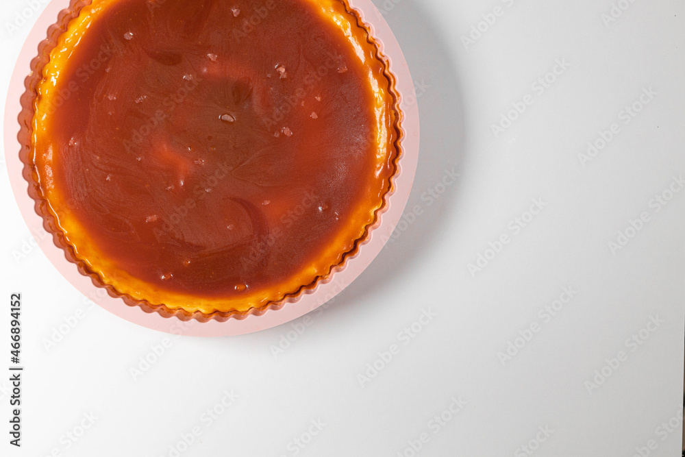 Classic cheesecake with caramel sauce on white plate on gray background. Copy space for text. Classic cheesecake with caramel sauce on white plate on gray background. Copy space for text.