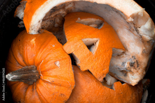 Background. An old, spoiled pumpkin monster in the trash can. Cleaning up after halloween.