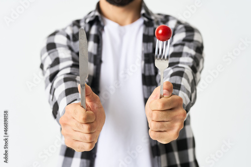 bearded man with kitchen utensils cherry tomatoes snack