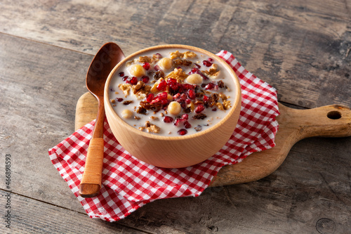 Traditional Turkish Noah's pudding in bowl on wooden table	
 photo