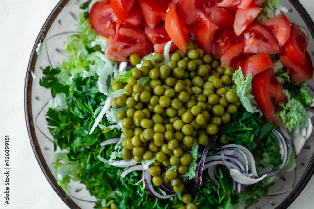 Fresh vegetable salad with Chinese cabbage, tomato, green peas, parsley. Healthy food.