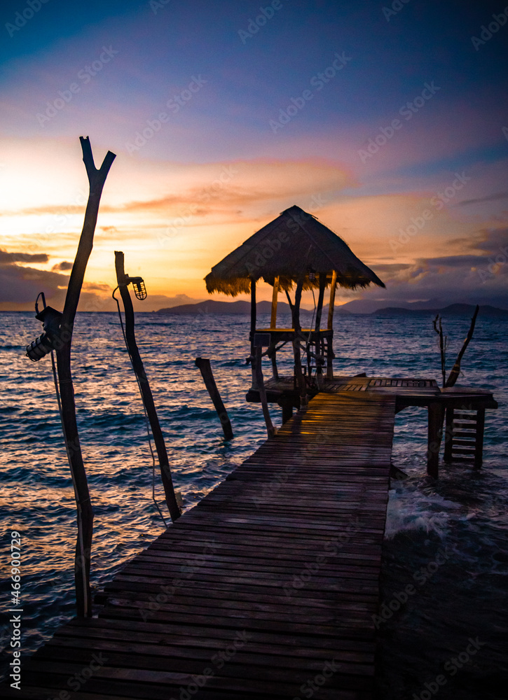 Sunset over wooden beach bar in sea and hut on pier in koh Mak island, Trat, Thailand Sunset over wooden beach bar in sea and hut on pier in koh Mak island, Trat, Thailand