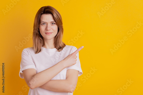 Photo of promoter lady direct finger empty blank space banner novelty wear casual clothes on yellow background