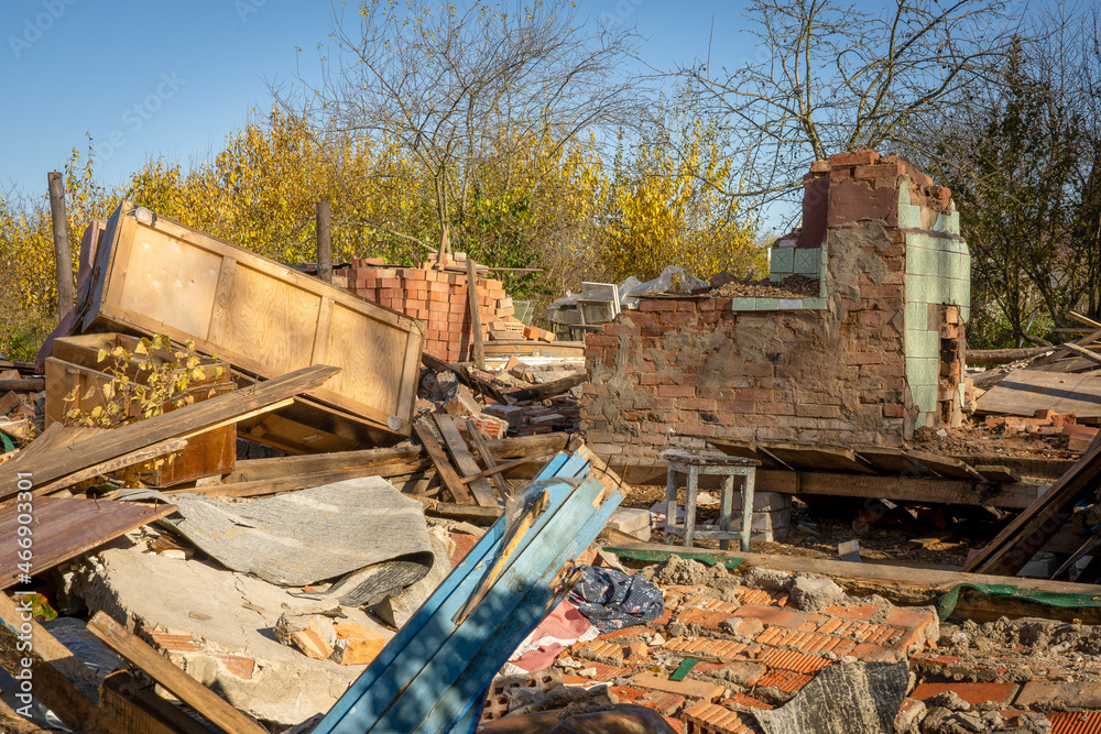 Photo of ruins of an old red brick building against the background of garbage, rubbish and junk on the street Photo of ruins of an old red brick building against the background of garbage, rubbish and junk on the street