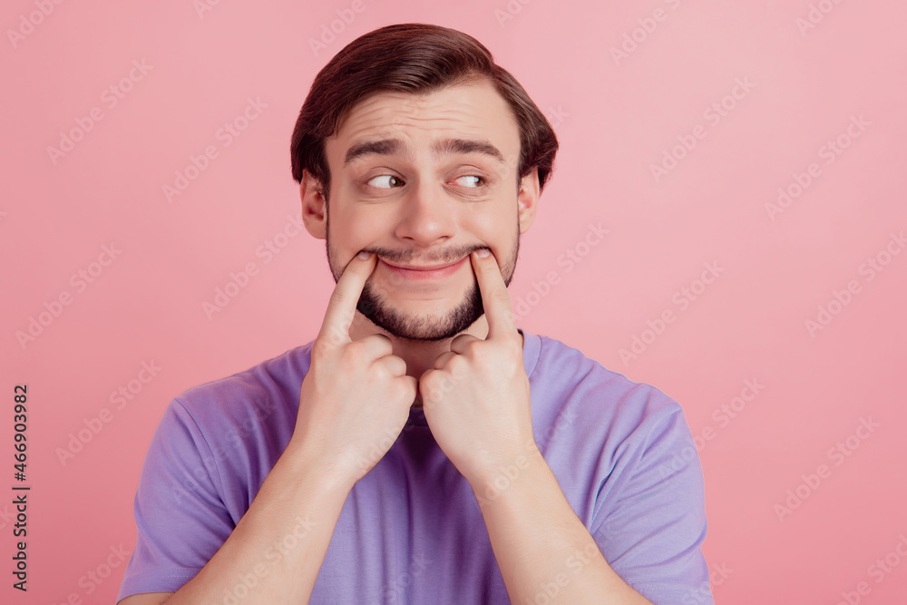 Photo of bored unhappy man look empty space fingers touch lips think dream isolated on pink color background Photo of bored unhappy man look empty space fingers touch lips think dream isolated on pink color background