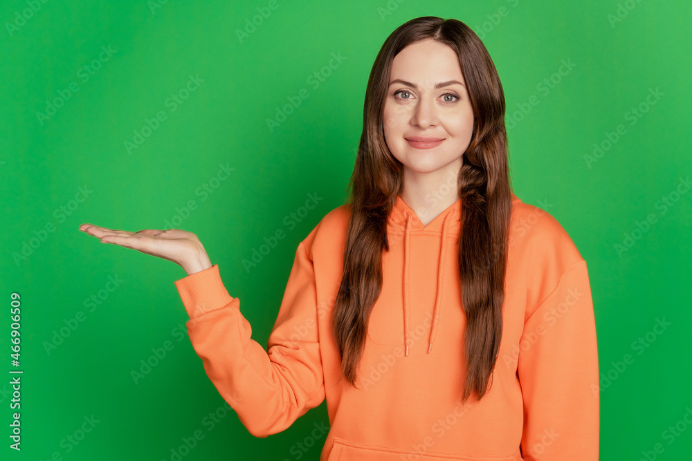 Portrait of charming lovely cheerful lady open palm hold empty space on green background Portrait of charming lovely cheerful lady open palm hold empty space on green background