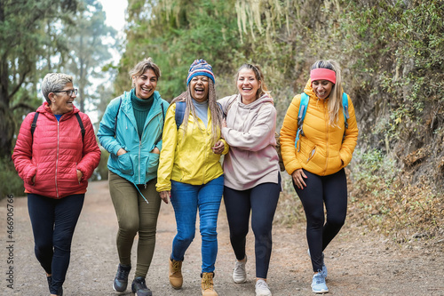 Multiracial women having fun during trekking day into the wood - Escape to the nature and travel concept - Focus on african woman face