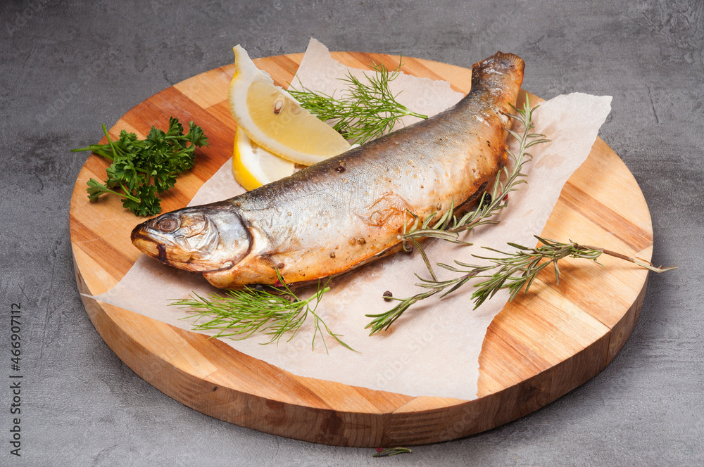 grilled river trout with lemon, rosemary on a wooden board grilled river trout with lemon, rosemary on a wooden board