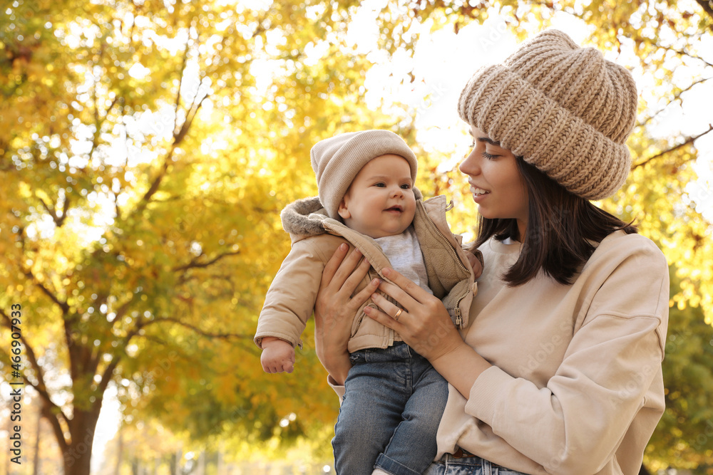 Happy mother with her baby son in park on autumn day, space for text Happy mother with her baby son in park on autumn day, space for text