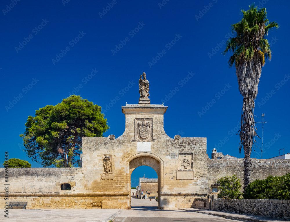 Obraz premium The small fortified village of Acaya, Lecce, Salento, Puglia, Italy. The large stone-paved square. The gateway to the city, with the large arch and the stone statue.
