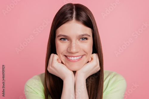 Portrait of nice girlish lady look in camera toothy smiling hands touch chin isolated over pink color background