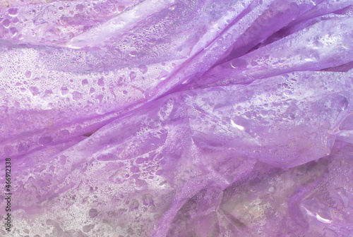 Folded purple plastic wrap and drops of water