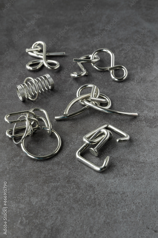 Brain games, metal puzzle on dark background Brain games, metal puzzle on dark background