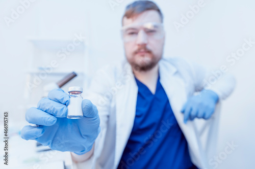 Mockup copy space blank label of medical vaccine vial bottle in doctor s hand wearing face mask and gloves. Hand holding vaccine glass bottle for injection