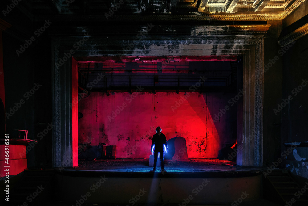 Man on the stage of creepy abandoned theater