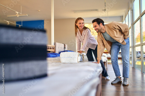 A young couple is choosing bedding at a bed, mattress and pillow store. Everything for a comfortable sleep.