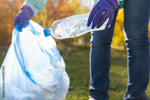 A female volunteer cleans plastic garbage in nature.