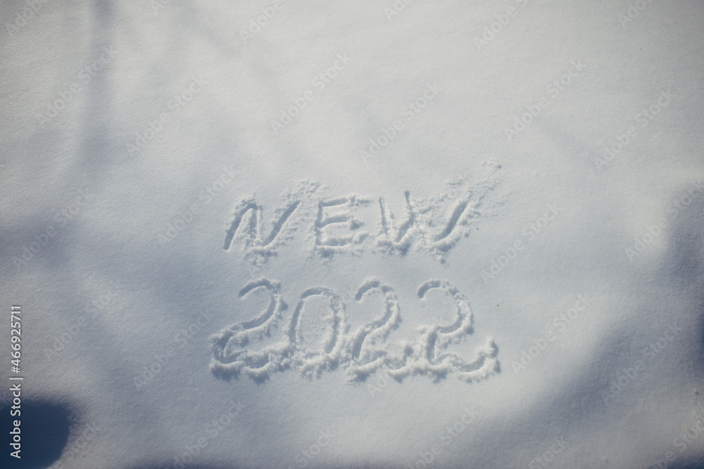 Drawing on white snow in sunlight. New Year's date, figures 2022, close-up. Winter holiday concept. Drawing on white snow in sunlight. New Year's date, figures 2022, close-up. Winter holiday concept.