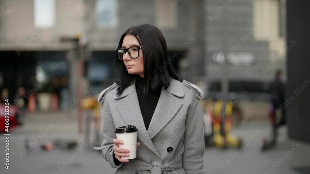 coffee to go, woman is walking in downtown and drinking hot tea or coffee coffee to go, woman is walking in downtown and drinking hot tea or coffee