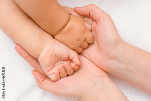 The hands of a sleeping baby in the mother's palms
