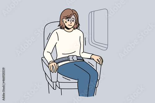 Aerophobia and being afraid of flights concept. Young stressed woman cartoon character sitting in plane near window feeling shock vector illustration  photo