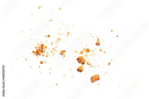 Scattered crumbs of vanilla chip butter cookies isolated on white background. Close-up view of brown crackers. Macro shot of yellow biscuit cake leftovers for your design photo