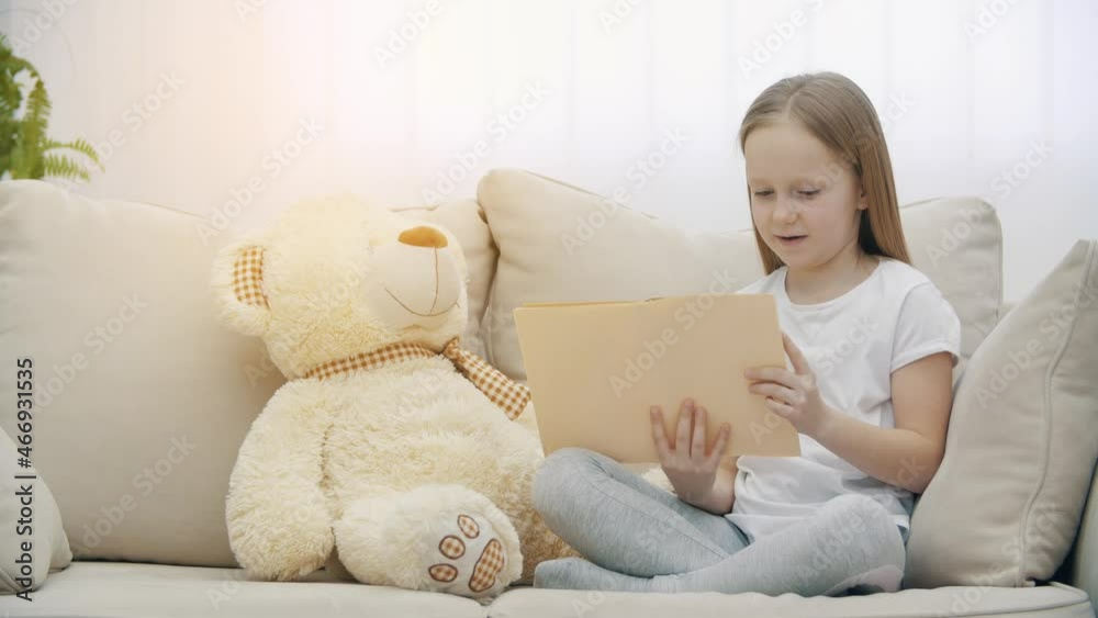4k slowmotion video of little girl reading a book to her teddy bear. 4k slowmotion video of little girl reading a book to her teddy bear.