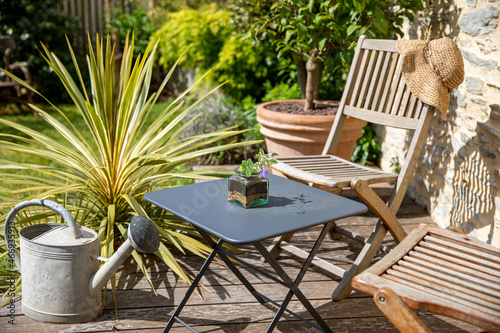 Canvastavla Salon de jardin sur une terrasse en bois dans un charmant jardinet au printemps
