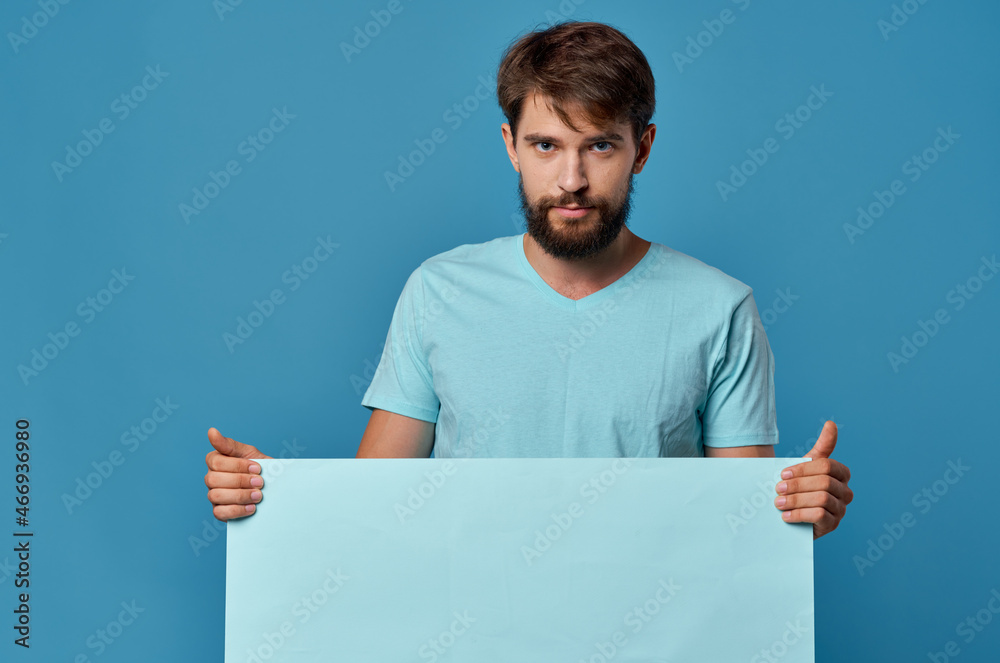 handsome man blue paper in the hands of marketing fun Lifestyle blue background handsome man blue paper in the hands of marketing fun Lifestyle blue background