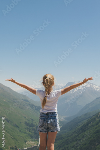 Happy preteen girl hiking on caucasian mountains in summer.