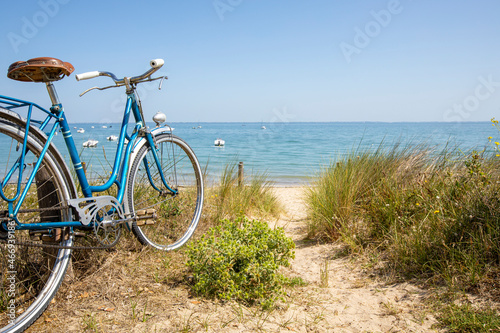 Fototapeta Naklejka Na Ścianę i Meble -  Vélo bleu en bord de mer abandonné par un baigeur le long de la plage.