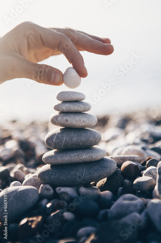 Photography Human hand putting last stone at the pyramid