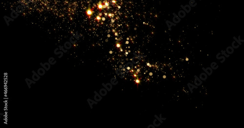 Gold particles fluid with light glitter and golden sparkles glow on background. Magic shine of stars or dust particles sparks with bokeh effect photo