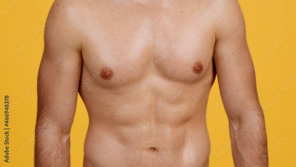 Close up shot of unrecognizable shirtless muscular man demonstrating his perfect abdominal muscles, tensing abs Close up shot of unrecognizable shirtless muscular man demonstrating his perfect abdominal muscles, tensing abs