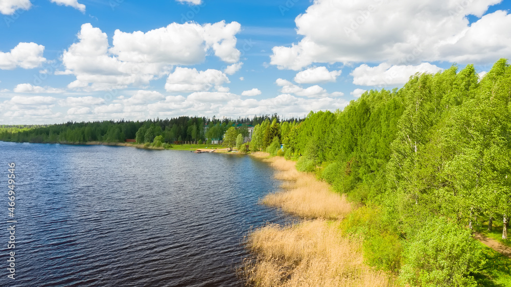 Top view of a blue long lake with green forests along the coast in Russia. Beautiful summer landscape. Top view of a blue long lake with green forests along the coast in Russia. Beautiful summer landscape.
