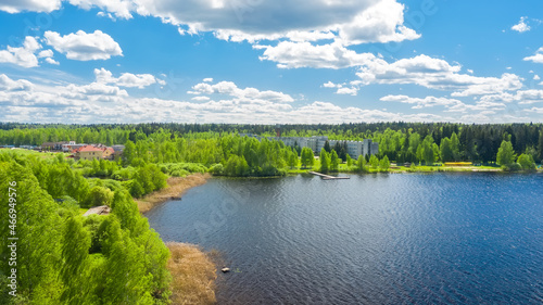 Top view of a blue long lake with green forests along the coast in Russia. Beautiful summer landscape.