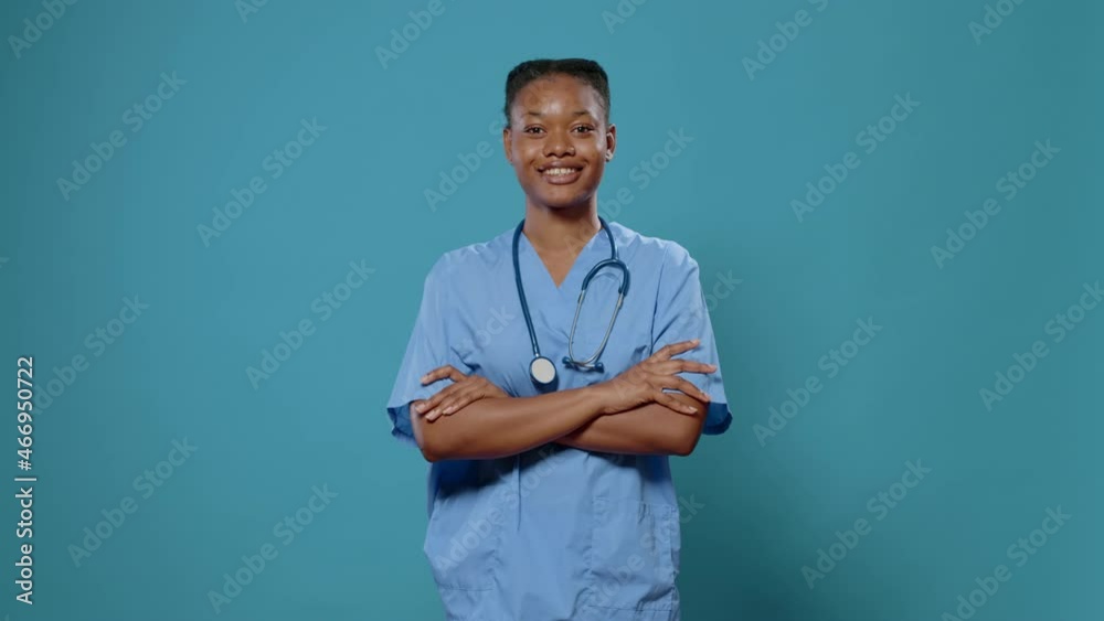 Medical assistant standing with crossed arms in studio. Woman nurse wearing uniform and stethoscope, having confidence about healthcare and expertise. Physician over blue background Medical assistant standing with crossed arms in studio. Woman nurse wearing uniform and stethoscope, having confidence about healthcare and expertise. Physician over blue background