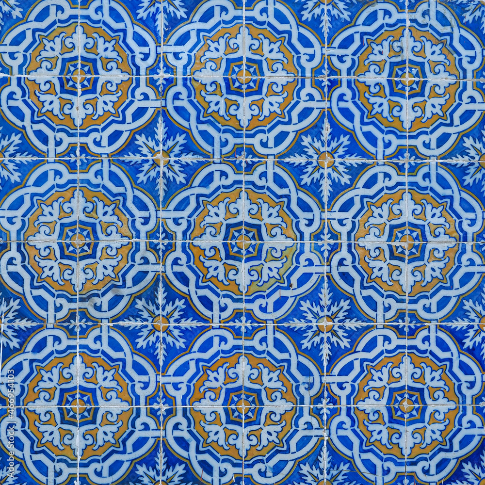 Fragment of building wall with vintage ceramic wall tiles, Azulejo, close up. Abstract decorative background, textured ornate pattern for design or backdrop. Traditional ornate Portuguese architecture