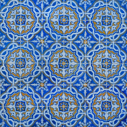 Fragment of building wall with vintage ceramic wall tiles, Azulejo, close up. Abstract decorative background, textured ornate pattern for design or backdrop. Traditional ornate Portuguese architecture